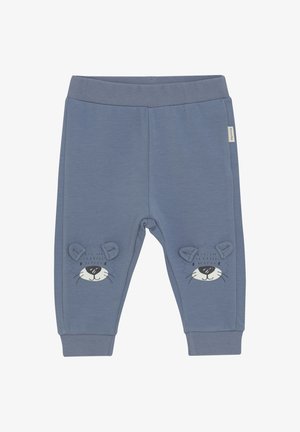 Pantalons de survêtement en coton bleu avec une texture lisse, présentant un design imprimé de tête de lion et des accents d'oreilles en 3D sur les jambes inférieures. Taille élastique.