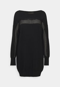 Robe-pull noire avec manches longues munies de panneaux en dentelle. La texture est lisse, et la silhouette est décontractée avec un ourlet effilé.