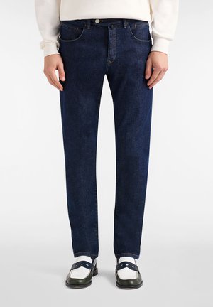 Temno modre kavbojke iz jeansa s krojem z ravnimi hlačnicami, z obliko s petimi žepi, nežnimi poudarki šivov in zapiranjem z gumbom na pasu.