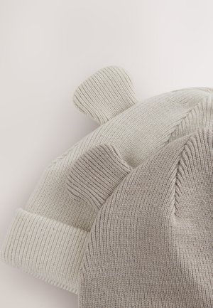 To huehuer: den ene er cremefarvet med tekstureret syning og bjørneører, den anden lysegrå med matchende ører. Begge har en ribbet kant.