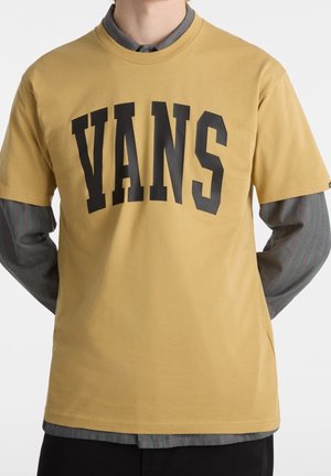 Żółta bawełniana koszulka z krótkim rękawem, z dużym czarnym napisem "VANS" z przodu. Klasyczny krój okrągłego kołnierza.