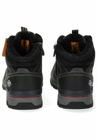 Botas de cuero negras con un collar de lana texturizada, cierre de cremallera y acento rojo a lo largo de la suela. Interior acolchado para calidez y comodidad.