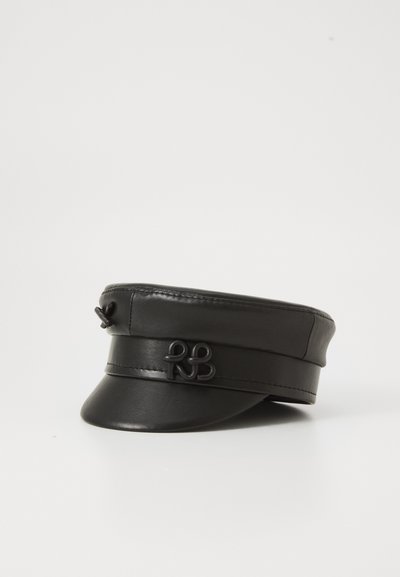 Gorra plana de cuero negro con visera corta, decorada con un emblema estilizado negro a juego en la banda frontal.