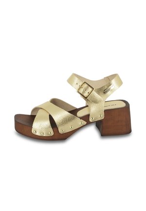 Gold metallic leather sandals with crossed straps, wooden platform, and block heel. Features a side buckle and decorative studs along the sole.