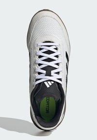 Witte en zwarte sportschoen met een bovenwerk van gaas, witte veters, een gevoerde zwarte kraag en een neon groene binnenzool met het label "Predator."