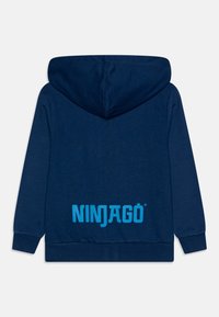 Felpa blu navy realizzata in tessuto morbido, con un grande logo cyan "NINJAGO" sul retro e cappuccio con coulisse. Vestibilità classica con polsini a costine.