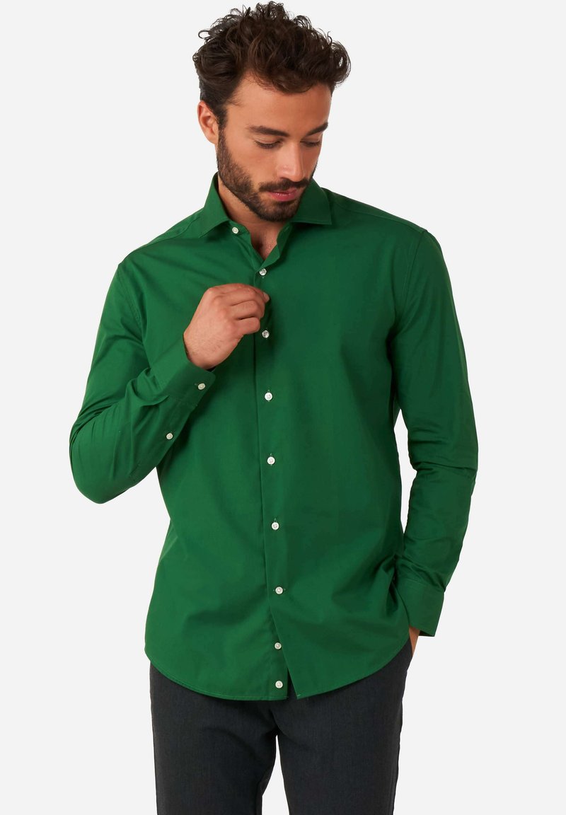 Camicia verde a maniche lunghe con bottoni realizzata in cotone. Presenta un colletto classico, bottoni bianchi e una vestibilità aderente. Tessuto morbido.