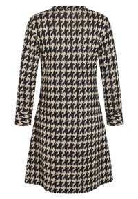 Robe à manches longues noire et beige à motif pied-de-poule avec une jupe légèrement évasée, vue de dos sur un fond blanc.
