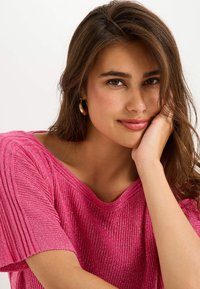 Top de punto texturizado en color rosa, con escote amplio y mangas cortas; presenta hilos metálicos sutiles para añadir brillo.