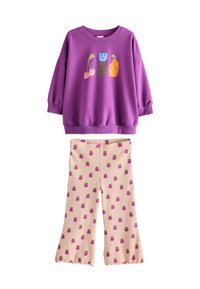 Lila Sweatshirt mit verspieltem Obst-Graphic; passende beige Hose mit kleinen rosa Obstmustern. Weicher Stoff, lockerer Schnitt, ausgestelltes Bein-Design.