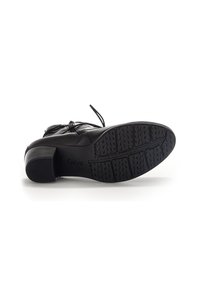 Bottines en cuir noir à bout carré, design à lacets et semelle en caoutchouc texturée. Dotées d'un petit talon carré pour la stabilité.