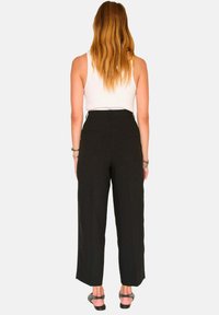 Pantalons noirs taille haute à jambes larges, en tissu doux, avec deux poches arrière et une coupe décontractée.