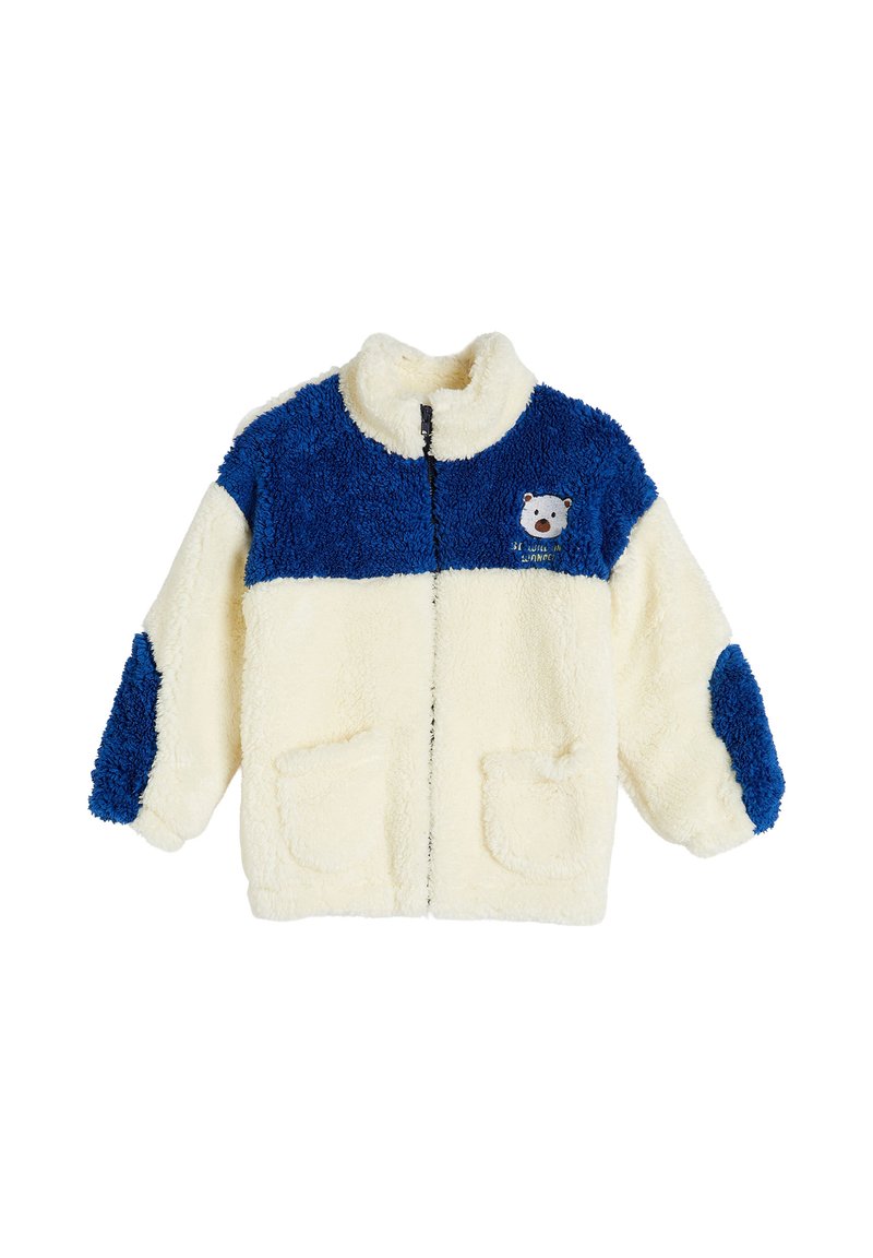 Chaqueta de forro polar con bloques de color crema y azul, cuello alto, cierre de cremallera, dos bolsillos frontales y un logo de oso impreso en el pecho.
