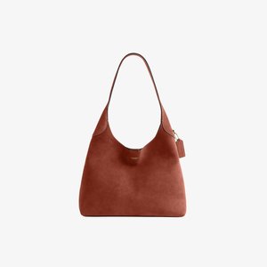 Borsa a tracolla in pelle marrone con un solo cinturino, logo discreto sotto l'apertura e un piccolo etichetta attaccata vicino alla parte superiore su sfondo bianco.