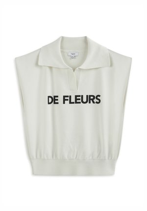 Top sans manches crème clair avec un col polo, présentant un imprimé central à l'avant avec l'inscription "DE FLEURS" en lettres noires en gras. Texture douce.
