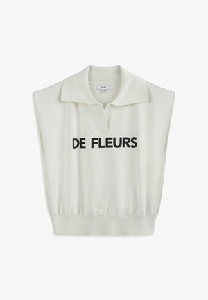 Světlý krémový bezrukávový top s polo límcem, s předním středovým potiskem, který uvádí "DE FLEURS" tučným černým písmem. Jemná textura.