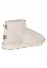 Beżowe botki za kostkę wykonane z zamszu z puszystym wnętrzem, z okrągłym noskiem, kontrastującym białym przeszyciem oraz płaską gumową podeszwą.