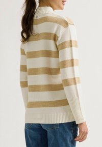 Pullover in Creme mit kräftigen beigefarbenen Streifen. Mit hohem Kragen, gerippten Bündchen und Saum sowie einem Logo-Detail auf der Rückseite. Lockerer Sitz.