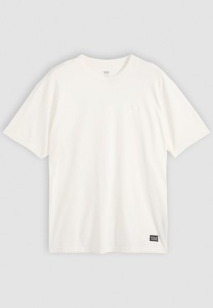 Vit kortärmad T-shirt i bomull, med rund halsringning och en liten logotyp på nedre vänster sida. Snygg och slät textur.