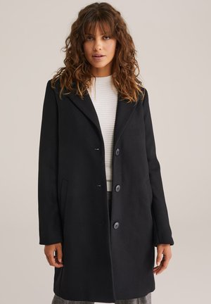 Zwarte wolmix jas met notch-lapels, drieknoopsluiting aan de voorkant en zijzakken. Glad textuur en een lichte oversized pasvorm.
