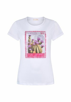 T-shirt blanc à manches courtes avec un motif coloré de timbre-poste représentant des cactus en fleurs et le texte "Explore Lands Unknown" sur le devant.