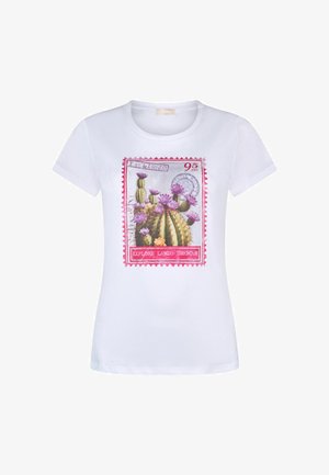 T-shirt blanc à manches courtes avec un motif coloré de timbre-poste représentant des cactus en fleurs et le texte "Explore Lands Unknown" sur le devant.