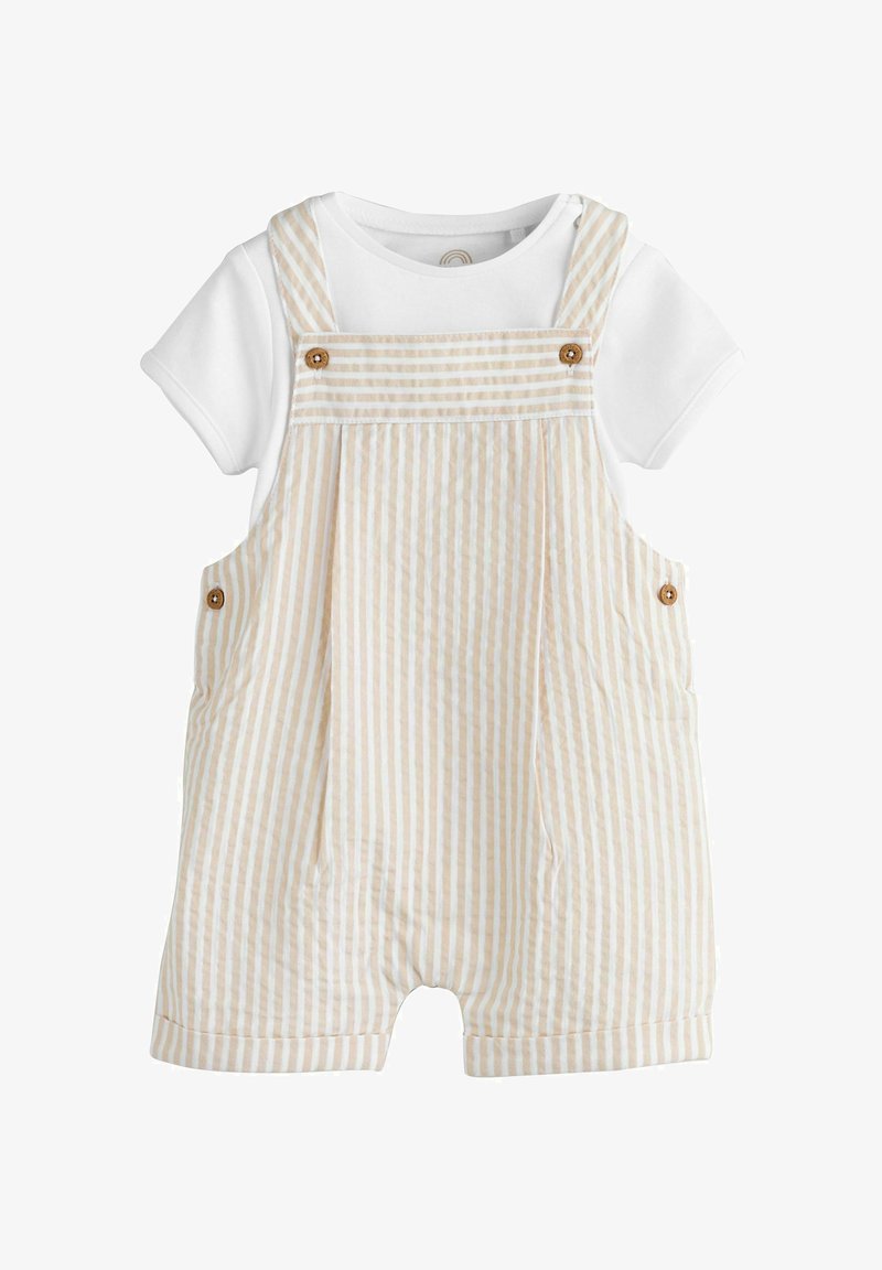 Weißes kurzärmeliges Hemd kombiniert mit beigen und weißen, vertikal gestreiften kurzen Latzhosen mit Holzknopfdetails an Trägern und Seiten.