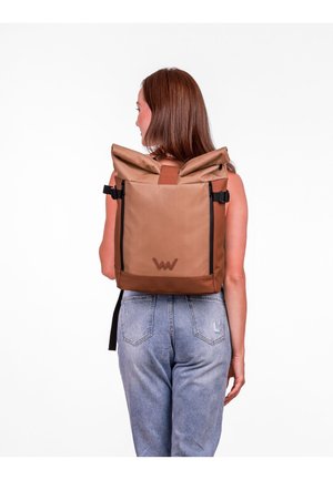 Hnědý batoh s rolovacím víkem vyrobený z odolného materiálu, s akcentem loga, nastavitelné popruhy a elegantním obdélníkovým designem.