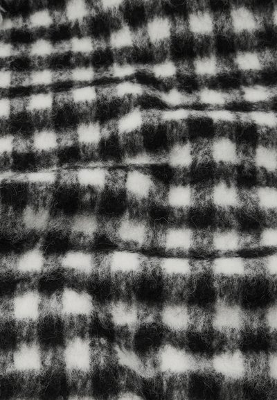 Tecido quadriculado em preto e branco com uma textura suave e felpuda. O padrão apresenta quadrados alternados em tamanhos variados.