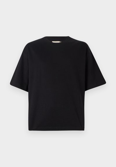 Camiseta negra de manga corta fabricada en suave algodón. Presenta un escote redondo y un ajuste suelto y cuadrado. Diseño minimalista sin logotipos visibles.