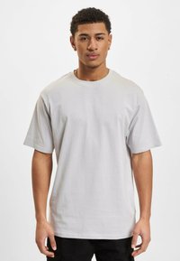 Lys grå bomulds T-shirt med korte ærmer, rund halsudskæring og en afslappet pasform. Glat tekstur, minimalistisk design, ingen synlige mønstre eller accenter.