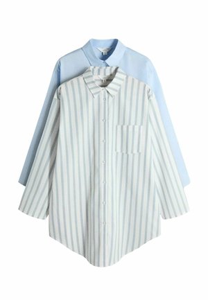 Dos camisas de manga larga con botones, una de color azul claro sólida y otra blanca con rayas azules verticales y un bolsillo en el pecho, superpuestas sobre un fondo blanco.