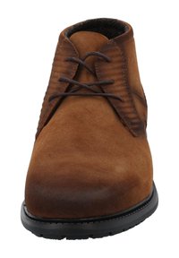 Stivaletto in suede marrone con chiusura stringata, punta arrotondata e dettagli testurizzati. Suola in gomma nera con moderato dettaglio di battistrada.