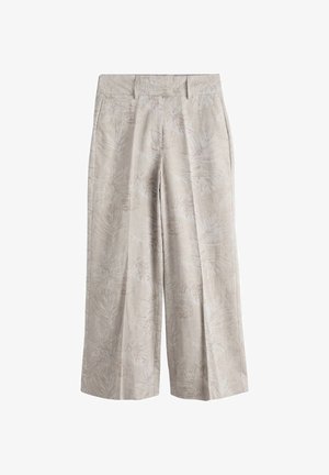 Beżowe spodnie o szerokich nogawkach z subtelnym wzorem liści, szlufkami na pasek i plisami z przodu, prezentowane na białym tle.