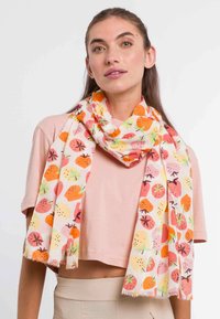 Let vejrsik scarf i creme med et farverigt frugt mønster med jordbær og andre frugter. Løst vævede kanter tilføjer tekstur.