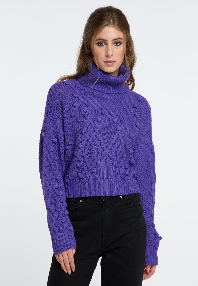 Fialový pletený rolák s textúrovanými vzormi a zdvihnutými akcentmi, s krátkym strihom a dlhými, priliehavými rukávmi.