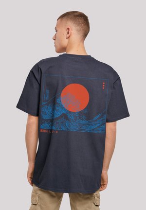 Navy blue cotton t-shirt featuring a graphic print of a red sun and blue waves on the back, with Japanese text and a rectangular border.