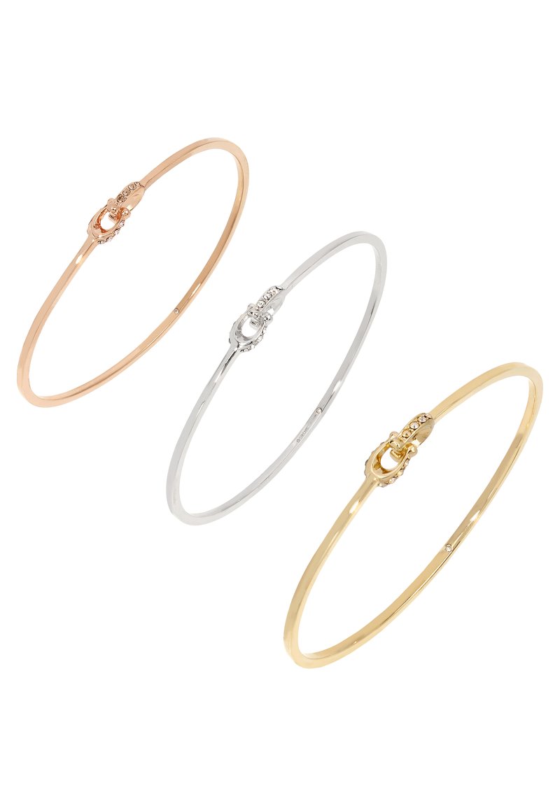 Conjunto de tres brazaletes delgados en oro rosa, plata y oro amarillo, que presentan un diseño de cierre sutil con pequeñas embellishments.