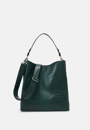 Dark green handbag with crocodile texture, a top handle, and an adjustable shoulder strap against a plain light background.