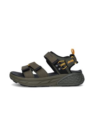 Sandalia de estilo outdoor en verde oliva con suela negra, tiras ajustables, lengüeta amarilla y logo de Jeep en la tira lateral.