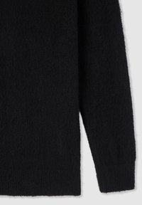 Maglione nero e peloso con una texture morbida, maniche lunghe e orlo a coste. Inquadratura ravvicinata che mette in evidenza lo spessore e l'aspetto del tessuto.