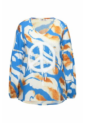 Blusa de manga larga en azul y blanco con un gran gráfico de signo de paz blanco que presenta acentos en naranja y amarillo, y una textura sedosa y suave.