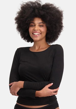 Zwart shirt met lange mouwen gemaakt van zachte, rekbare stof met een ronde hals en een aansluitend ontwerp, gedragen door een persoon met krullend haar.