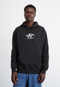 Sort sweatshirts med en forlommek, snore og et hvidt Volcom-logo. Har en afslappet pasform og ribbede manchetter.
