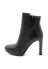 Czarne skórzane botki za kostkę z wysokim obcasem w kształcie stiletto, spiczastym czubkiem i minimalistycznym designem z złotymi akcentami przy mankiecie.