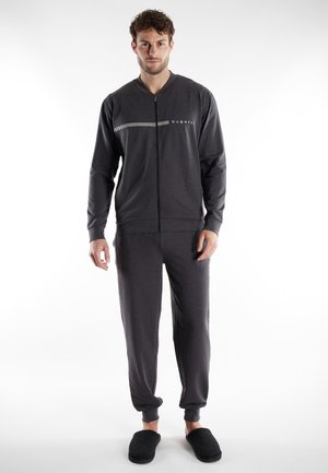 Gray zip-up jacket with a subtle striped design and logo, paired with matching tapered pants. Soft fabric and relaxed fit. Black slippers.