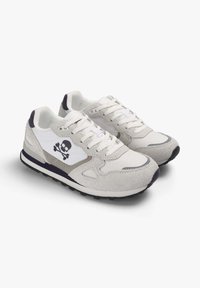Zapatillas que combinan malla blanca y ante gris claro, con un logo de calavera negro en el lateral y una suela de goma oscura.