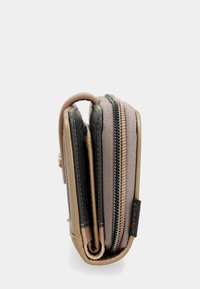 Cartera compacta en beige y negro, con cierre de cremallera y texturas distintas. Exterior de cuero suave con un detalle de patrón cosido.