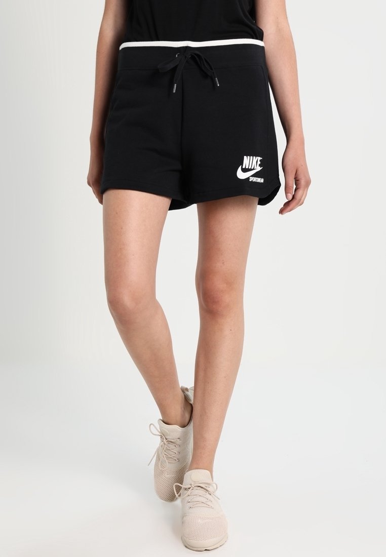 Pantalones cortos negros de Nike con logo blanco, cintura elástica y cordón. Tejido suave, longitud a mitad del muslo, diseño simple sin patrones.