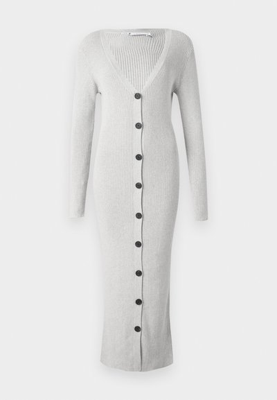 Long grey ribbed cardigan with a V-neck, full sleeves, and eight black buttons down the front. Mid-calf length with a textured finish.